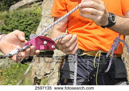 Man adjusting rock climbing gear View Large Photo Image Stock Photography - Man adjusting rock climbing gear . Fotosearch