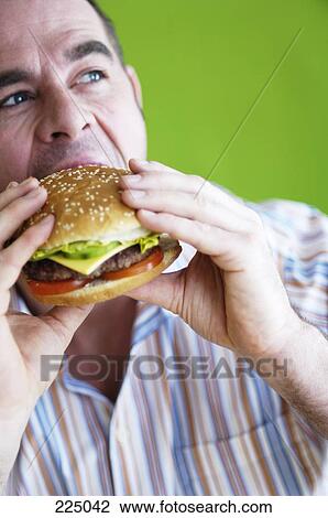 Stock Image - Man eating burger . Fotosearch