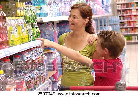 Mid adult woman and her son shopping in supermarket View Large Photo Image Stock Photo - Mid adult woman and her son shopping in supermarket . Fotosearch