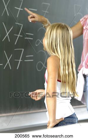 Midsection view of teacher explaining girl on blackboard View Large Photo Image Stock Photography - Midsection view of teacher explaining girl on blackboard . Fotosearch