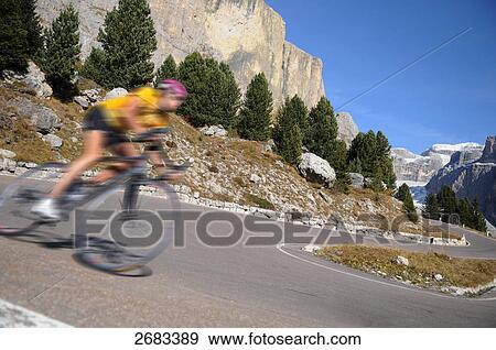 Mountain biker in motion on country road, Dolomites, Italy View Large Photo Image Stock Photo - Mountain biker in motion on country road, Dolomites, Italy . Fotosearch
