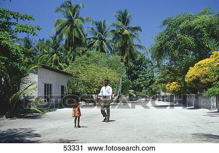 Stock Image - Native people in village lane, Maldives . Fotosearch