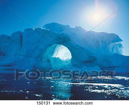 Stock Image - Natural arch formed in a ice burg in the sea, Umanak, Greenland . Fotosearch