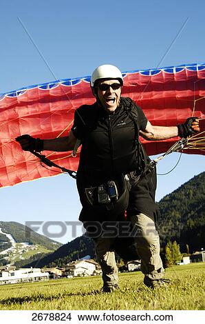 Picture - Paraglider running to takeoff . Fotosearch