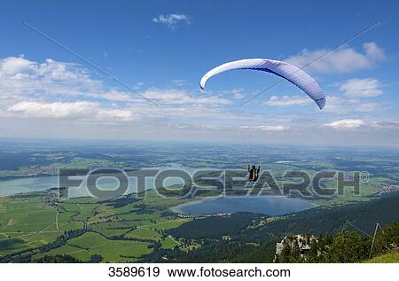 Stock Photo - Paraglider view to Fuessen and Forggensee, Bavaria, Germany, Europe . Fotosearch