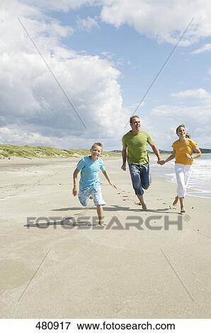 Parents with son running at beach View Large Photo Image Stock Photo - Parents with son running at beach . Fotosearch