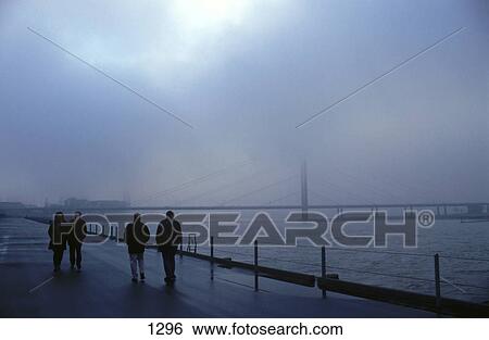 People walking at riverbank in fog, Rhein River, Dusseldorf, North Rhine-Westphalia, Germany View Large Photo Image Stock Photograph - People walking at riverbank in fog, Rhein River, Dusseldorf, North Rhine-Westphalia, Germany . Fotosearch