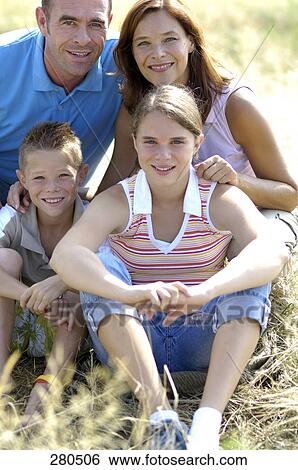 Stock Photograph - Portrait of family smiling in field . Fotosearch