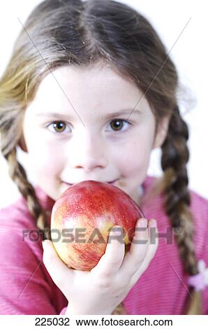 Stock Image - Portrait of girl eating apple . Fotosearch