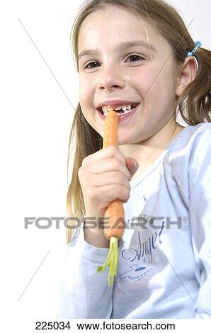 Picture - Portrait of girl eating carrot . Fotosearch