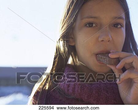 Picture - Portrait of girl eating chocolate . Fotosearch
