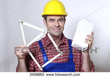 Stock Image - Portrait of man holding folding ruler and smiling . Fotosearch