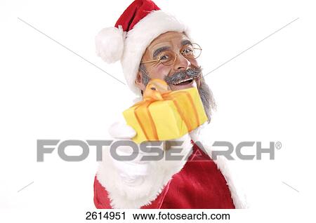 Stock Image - Portrait of senior man in santa costume giving Christmas gift . Fotosearch