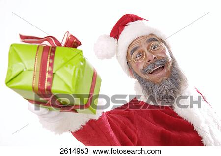 Stock Image - Portrait of senior man in santa costume giving Christmas gift . Fotosearch