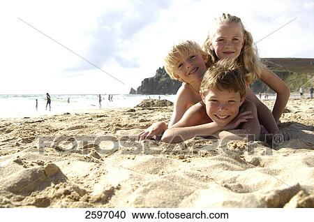 Portrait of three children lying on beach and smiling View Large Photo Image Stock Image - Portrait of three children lying on beach and smiling . Fotosearch
