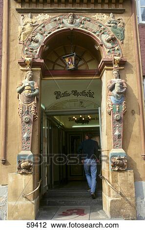 Stock Image - Rear view of man at entrance door, Luneburg, Saxony, Germany, Europe . Fotosearch