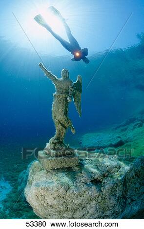 Scuba diver flashing light on sunken statue underwater View Large Photo Image Stock Image - Scuba diver flashing light on sunken statue underwater . Fotosearch