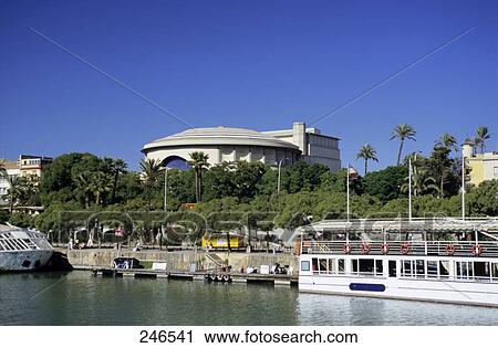Ship in river with opera house in background, Teatro de la Maestranza, Seville, Andalusia, Spain View Large Photo Image Stock Image - Ship in river with opera house in background, Teatro de la Maestranza, Seville, Andalusia, Spain . Fotosearch