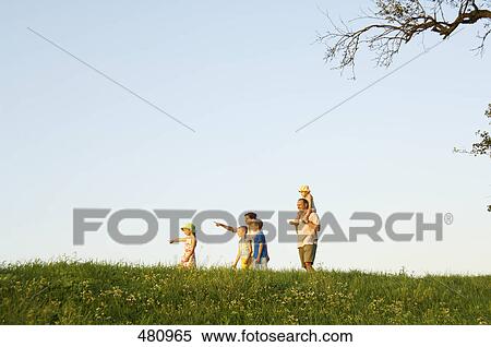 Stock Photography - Side profile of family walking in field . Fotosearch