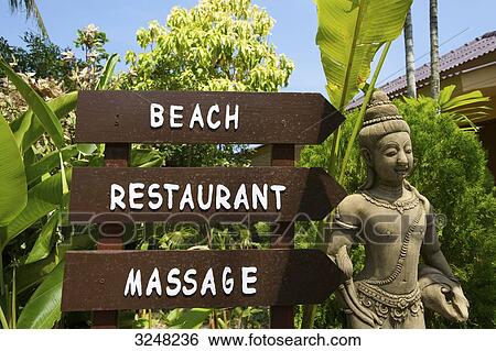 Stock Photograph - Signpost and statue, Ko Samui, Thailand . Fotosearch