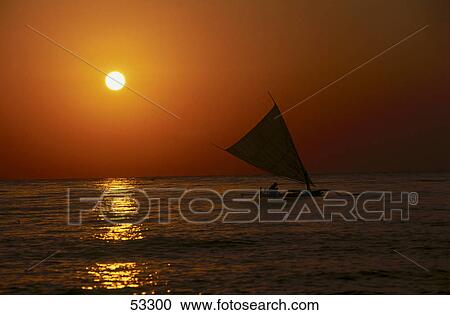 Stock Image - Silhouette of sailboat in sea at sunset, Bali, Indonesia . Fotosearch