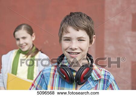 Smiling boy with headphones and girl with folder View Large Photo Image Stock Photo - Smiling boy with headphones and girl with folder . Fotosearch