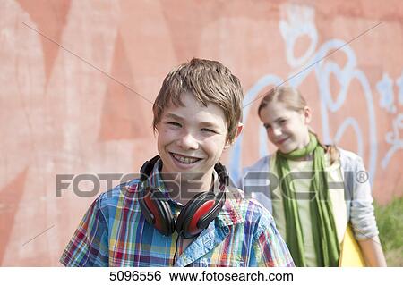 Smiling boy with headphones and girl with folder View Large Photo Image Stock Photograph - Smiling boy with headphones and girl with folder . Fotosearch