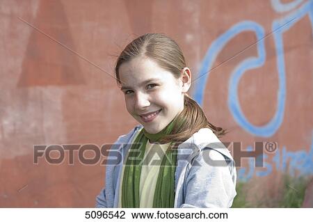Smiling girl in front of graffiti wall, portrait View Large Photo Image Stock Image - Smiling girl in front of graffiti wall, portrait . Fotosearch