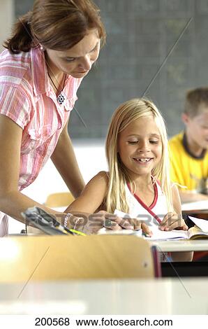 Teacher teaching girl in classroom View Large Photo Image Stock Photo - Teacher teaching girl in classroom . Fotosearch