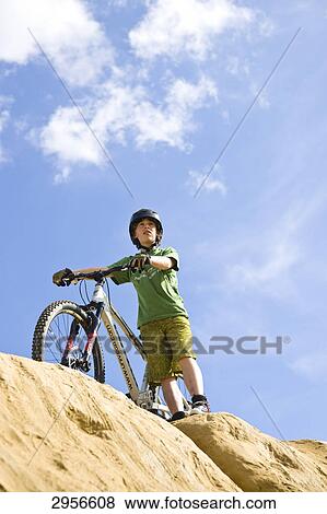 Stock Photo - teenage mountain biker, view from below . Fotosearch