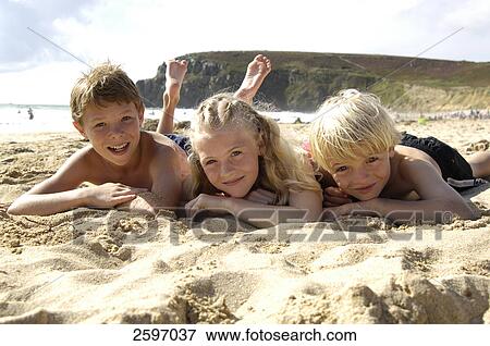 Three children lying at beach View Large Photo Image Stock Photo - Three children lying at beach . Fotosearch