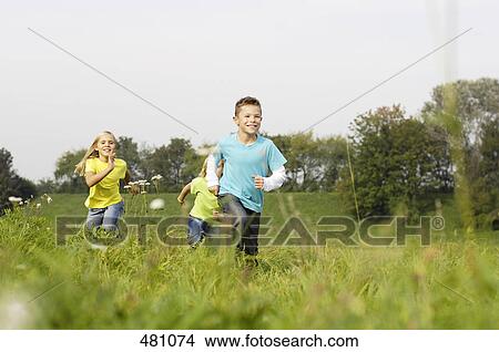 Picture - Three children running in field . Fotosearch
