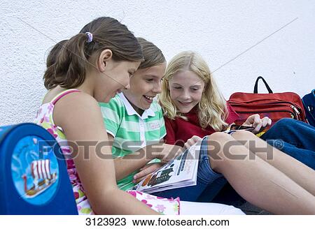 Three girls reading a magazin View Large Photo Image Stock Image - Three girls reading a magazin . Fotosearch