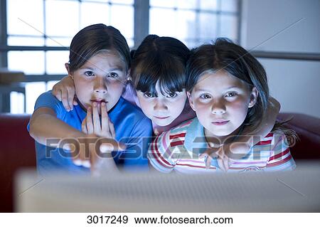 Three girls sitting in front of a computer, front view View Large Photo Image Stock Photo - Three girls sitting in front of a computer, front view . Fotosearch