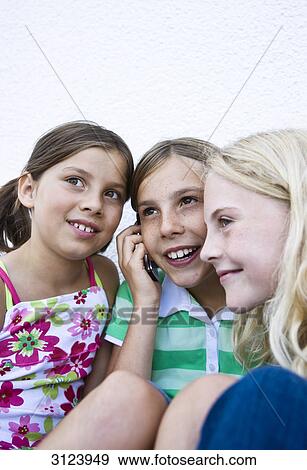 Three girls using a mobile phone, close-up View Large Photo Image Stock Photo - Three girls using a mobile phone, close-up . Fotosearch