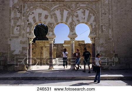 Stock Image - Tourists looking ruins of castle, Portico de Medina Azahara, Medina Azahara, Cordoba, Andalusia, Spain . Fotosearch