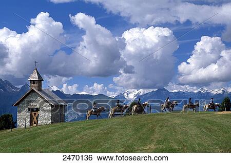 Stock Photograph - Tourists riding on horses with mountain range in background, Hohe Tauern, Alps, Moelltal, Carinthia, Austria . Fotosearch