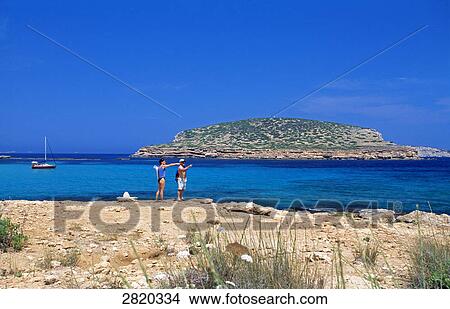 Picture - Tourists standing at coast, Cala Comte, Ibiza, Balearic Islands, Spain . Fotosearch