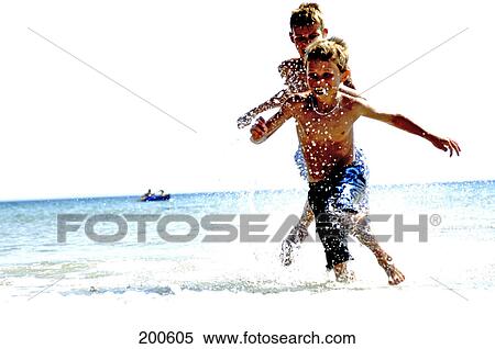 Two boys playing in water on beach View Large Photo Image Stock Photography - Two boys playing in water on beach . Fotosearch