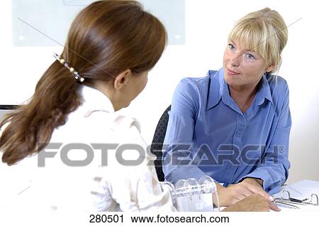 Two businesswomen discussing in office View Large Photo Image Stock Image - Two businesswomen discussing in office . Fotosearch