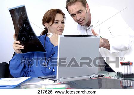 Two doctors looking at laptop View Large Photo Image Stock Photograph - Two doctors looking at laptop . Fotosearch