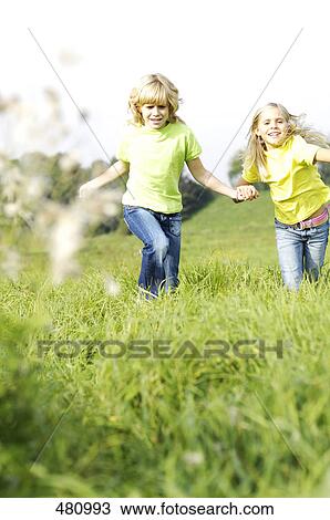 Two girls running in field View Large Photo Image Stock Image - Two girls running in field . Fotosearch