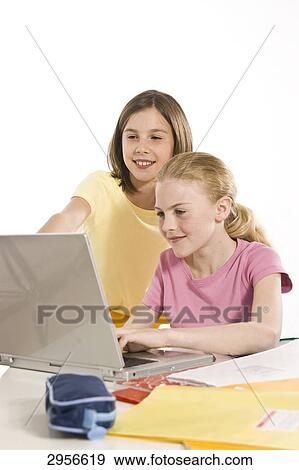 two girls using a notebook View Large Photo Image Stock Photo - two girls using a notebook . Fotosearch