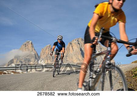 Stock Image - Two mountain bikers cycling together, Dolomites, Italy . Fotosearch
