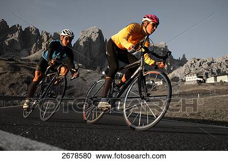 Stock Image - Two mountain bikers in motion, Dolomites, Italy . Fotosearch