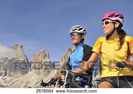 Two mountain bikers smiling together, Dolomites, Italy View Large Photo Image Picture - Two mountain bikers smiling together, Dolomites, Italy . Fotosearch