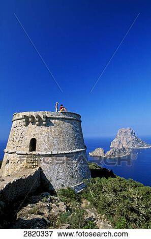 Stock Photo - Two people on defence tower, Es Vedra, Ibiza, Balearic Islands, Spain . Fotosearch