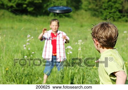 Two playing frisbee in a field View Large Photo Image Stock Photography - Two playing frisbee in a field . Fotosearch