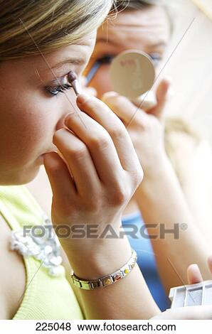 Two teenage girls painting faces with eyeshadow View Large Photo Image Stock Photo - Two teenage girls painting faces with eyeshadow . Fotosearch