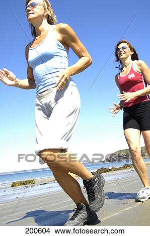 Two women jogging on beach View Large Photo Image Picture - Two women jogging on beach . Fotosearch